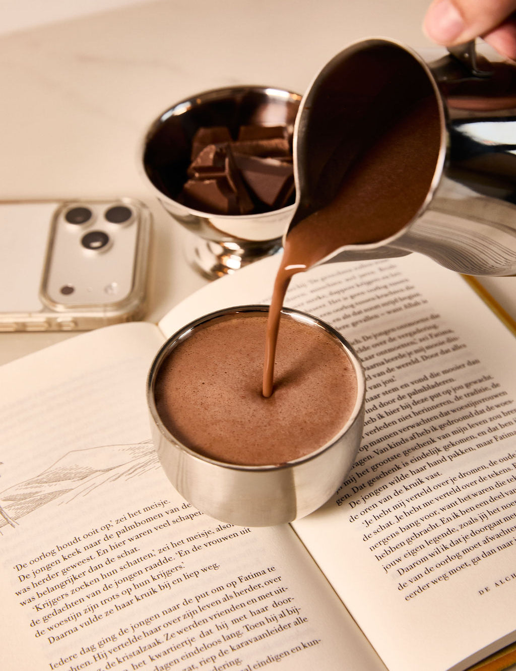 Ceremonial cacao poured into a cup during a calm morning ritual with a book
